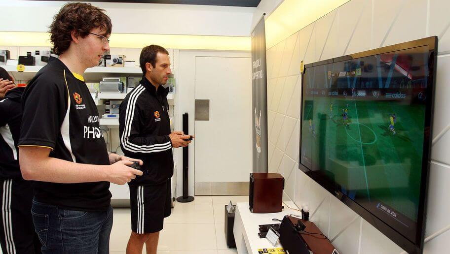WELLINGTON, NEW ZEALAND - MARCH 27:  Andrew Durante plays a Playstation game with a Phoenix supporter during the Wellington Phoenix A-League Finals Series launch at Sony Store on March 27, 2012 in Wellington, New Zealand.  (Photo by Hagen Hopkins/Getty Images)